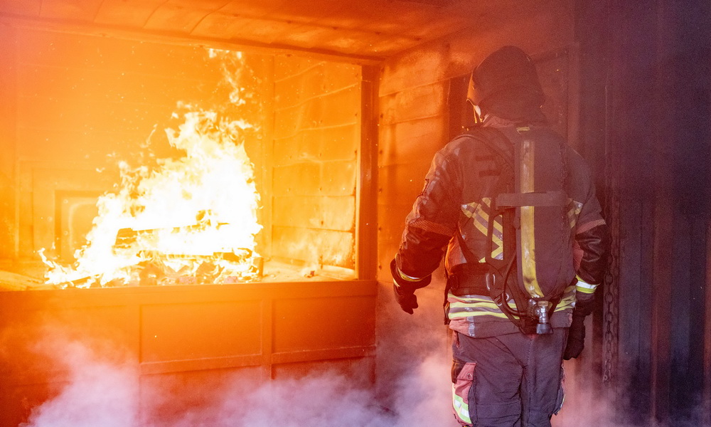 Ein Proband mit einem Prototyp einer intelligenten Feuerwehrjacke in der Brandsimulationsanlage © Salzburg Research/wildbild